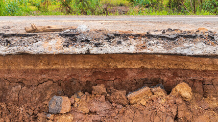 The soil layer has been eroded under the rural paved road.