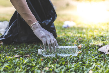 Male volunteers carry water bottles or plastic bags that have fallen in the park put them in trash cans, Environmental protection or volunteering for charity, Waste disposal through recycling.