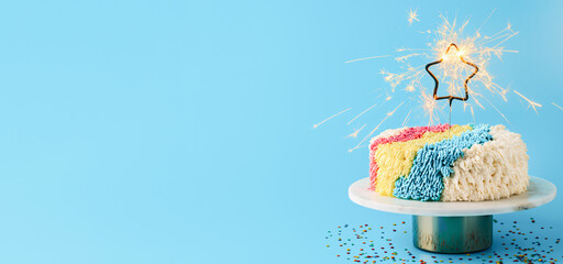 Shag cake with burned sparkler star on blue background. Colorful shag cake with perfect vanilla...