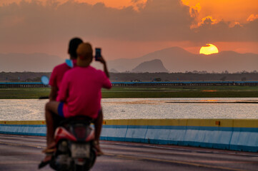 Fototapeta premium Take pictures of the sunset with a smartphone