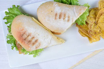 Ham, cheese and lettuce sandwich on white wooden background