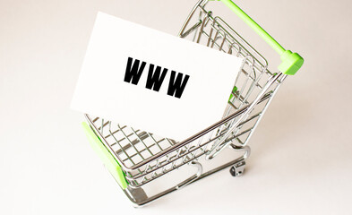Shopping cart and text WWW on white paper. Shopping list concept.