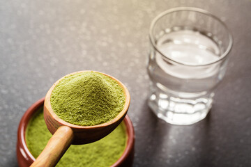 Freeze-dried wheatgrass powder and glass of water.	
