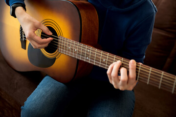 Fototapeta premium Close-up woman playing acoustic guitar. Selective focus