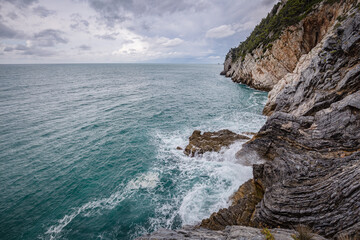 Seascape. Stormy sea on a windy day: blue waves breaks on the stone shore