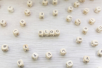 Word Blog made with block wooden letters cubes in centre surrounded by pile of other letters on wooden surface. Content marketing, blogging concept