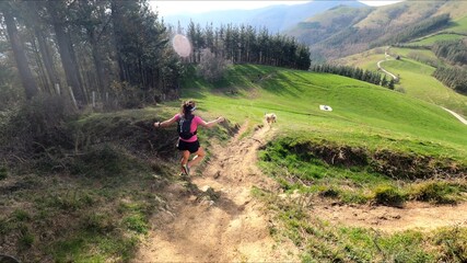 young woman trail running in the mountains