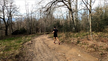 Fototapeta premium young man trail running in the mountains