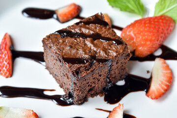 Top view, Chocolate brownies decorated with chocolate cream and fresh strawberries.