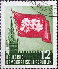 GERMANY, DDR - CIRCA 1953 : a postage stamp from Germany, GDR showing the Kremlin in Moscow, flag with head images of Marx, Engels, Lenin and Stalin. On the 70th anniversary of Karl Marx's death