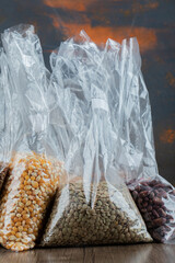 Different kinds of beans packed on a gray background