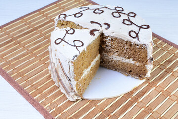 Cake decorated with vanilla and arequipe on white plate and light colored wooden background