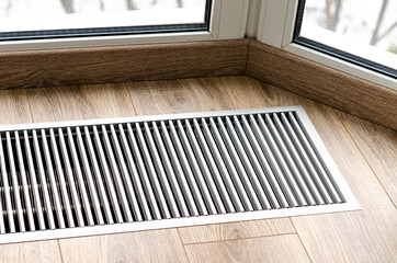Protective grille mounted on the floor to heat the panoramic window