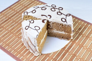 Cake decorated with vanilla and arequipe on white plate and light colored wooden background