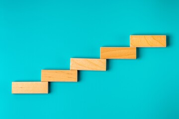 Wooden blocks in the form of steps of a ladder against a background of color of sea water.