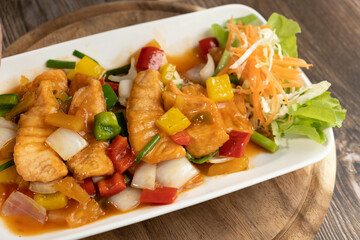 Salmon Sweet and Sour Stir Fried on wooden background ready to eat
