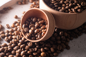 Dark Coffee Beans in a wooden Cup. Symbolic image. Rustic wooden background. Close up. Copy space.