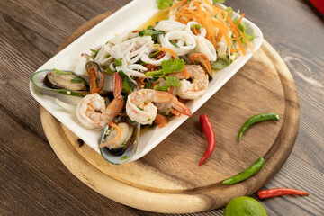 Seafood Spicy Salad on the wooden background ready to eat