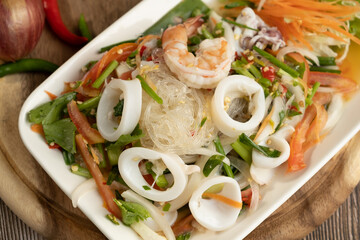 Seafood Spicy Salad on the wooden background ready to eat