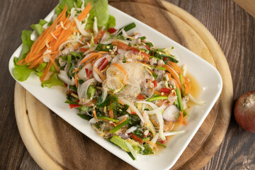 Seafood Spicy Salad on the wooden background ready to eat
