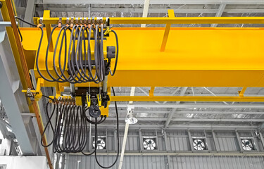 Overhead crane inside factory or warehouse. That industrial machinery or lifting equipment consist of hoist, hook and wire rope traveling on beam girder structure. For manufacturing production plant.