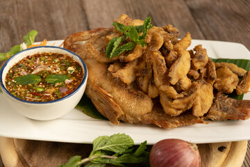 Fried Fish with Fish Sauce on the wooden background ready to eat