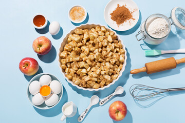 Cooking baking background with ingredients, fresh apples, spices and utensils on blue table.