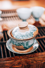 Gaiwan with tea stands on a wooden table for tea ceremonies