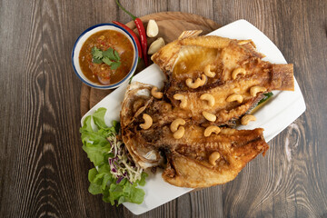Fried Fish with Fish Sauce on the wooden background ready to eat