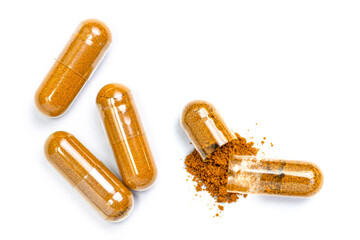 turmeric herbal powder capsules isolated on white background. Top view. Flat lay.