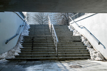 granite stairs with handrail at the end of the tunnel in winter