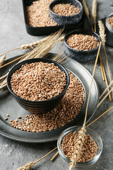 Bowls with wheat grains on grunge background