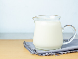 The pure milk drink in a jar is naturally healthy food placed on a gray cloth on a blue background.