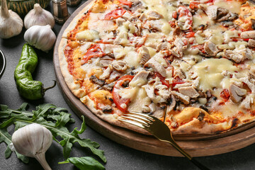 Board with tasty pizza on dark background