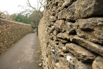 Old stone wall on side of a pedestrian walkway