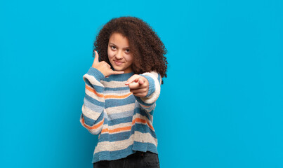  smiling cheerfully and pointing to camera while making a call you later gesture, talking on phone
