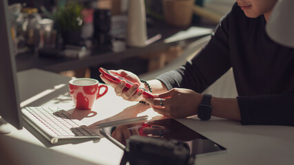 Young man hand Holding phone Office equipment placed on the table at the office