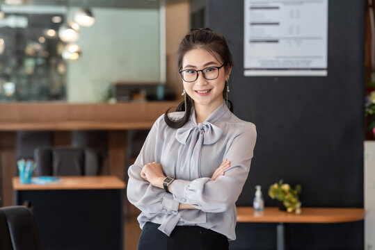 Image of a charming young asian businesswoman standing at the office. Looking camera.