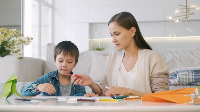 Mother and son are engaged in drawing at home