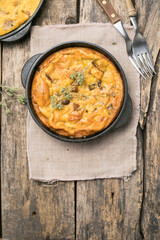Frittata with mushrooms in a pan on wooden background. Fritata is an Italian breakfast dish.