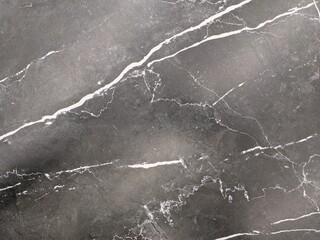 Dark marble texture with white stripes. Background.