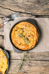 Frittata with mushrooms in a pan on wooden background. Fritata is an Italian breakfast dish.