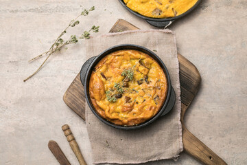 Frittata with mushrooms in a pan on wooden background. Fritata is an Italian breakfast dish.