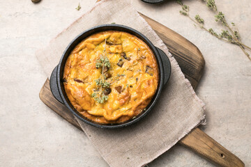 Frittata with mushrooms in a pan on wooden background. Fritata is an Italian breakfast dish.