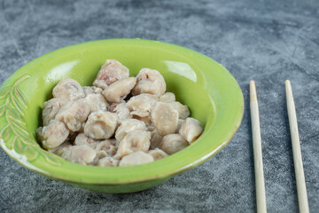 A green plate with delicious dumplings on a marble background