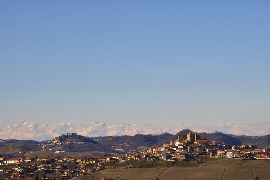 View of the Langhe vineyard hills (Unesco World Heritage Site) with the medieval villages of Roddi and  Monticello d'Alba and the Alps mountain range in the background in winter, Piedmont, Italy