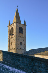 Fototapeta premium Top of a medieval bell tower in the ancient village of Serralunga d'Alba against clear blue sky, Cuneo, Piedmont, Italy