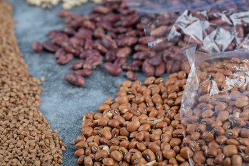 Different kinds of beans packed on a gray background