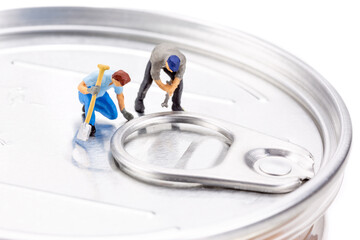 Miniature people trying to open the can lid