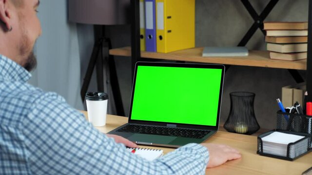 Green screen mock up chroma key display monitor laptop computer concept: Businessman at home office listen tells company top manager employee online conference webcam video call business meeting chat